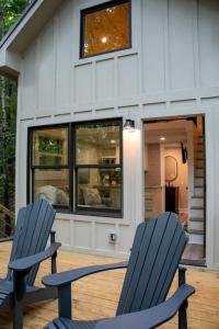 due sedie blu sedute di fronte a una casa di Amazing Tree House Perfect for a Secluded Getaway in Alabama a Grant Altre 25 foto
