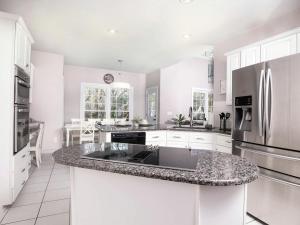 a kitchen with white cabinets and a granite counter top at Disconnect at this Cottage with Great Surroundings in Charlotte, North Carolina in Charlotte