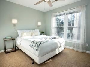 a bedroom with a bed with a ceiling fan and a window at Disconnect at this Cottage with Great Surroundings in Charlotte, North Carolina in Charlotte
