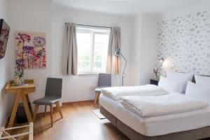 1 dormitorio con 2 camas, escritorio y ventana en Wailtl Hotel, en Dorfen