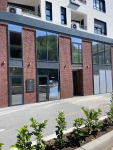 un edificio de ladrillo con puertas y ventanas de cristal en Breeze Stay Apartman, en Bijelo Polje