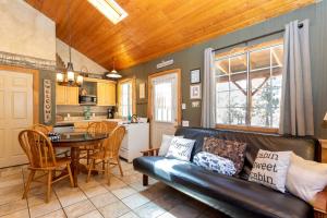a living room with a leather couch and a table at Traditional Forest Cabin for Four Guests in Angelus Oaks, California in Angelus Oaks