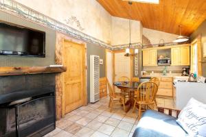 a kitchen and living room with a fireplace and a table at Traditional Forest Cabin for Four Guests in Angelus Oaks, California in Angelus Oaks