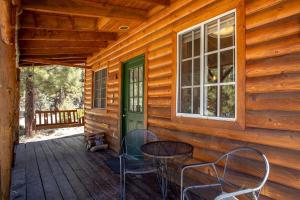 a porch of a cabin with a table and chairs at Traditional Forest Cabin for Four Guests in Angelus Oaks, California in Angelus Oaks