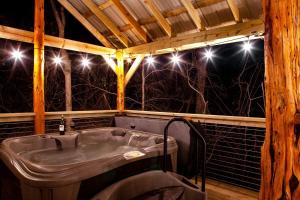bañera en una habitación con luces en Fantastic Treehouse with Fire Pit and Hot-tub in Herod, Illinois, en Karbers Ridge