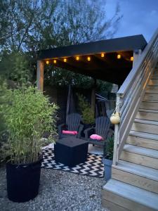 a patio with two chairs and a pergola with lights at TyGroaz studio in Porspoder in Porspoder