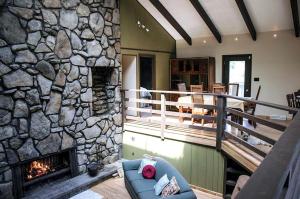 a living room with a stone wall and a fireplace at Cozy Bed and Breakfast Accommodation with a Shared Kitchen near Ohiopyle State Park in Confluence