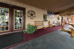 a store front with a bench and tables and windows at Americas Best Value Inn - Legend's Inn in Junction