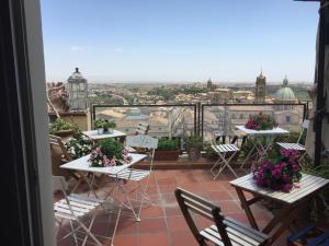 d'un balcon avec des tables et des chaises offrant une vue sur la ville. dans l'établissement Casa tipica siciliana patronale home BedandBreakfast TreMetriSoprailCielo Camere con vista, colazione interna in terrazzo panoramico, à Caltagirone