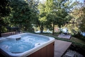 a jacuzzi tub in a yard with a pond at Lakefront Cozy Cabin with Hot-tub in Carbondale, Illinois in Etherton