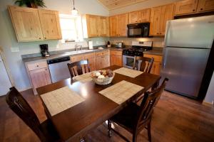 eine Küche mit Holztisch und Edelstahlkühlschrank in der Unterkunft Lakefront Cozy Cabin with Hot-tub in Carbondale, Illinois in Etherton