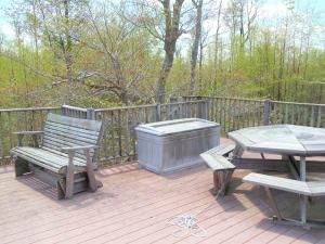 a wooden deck with a bench and a picnic table at Peaceful Cabin Rental for Groups on a Farm near Susquehannock State Forest, Pennsylvania in Short Run