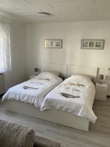 a bedroom with a large bed with white sheets at Schicke Ferienwohnung Philippsburg in Philippsburg