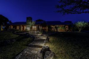 a house at night with a pathway leading to it at Impressive Modern Cabin with Beautiful Interior and Exterior in Ingram, Texas in Hunt