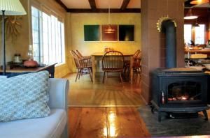 a living room with a fireplace and a table with chairs at Gorgeous, Lakefront Vacation Rental in the Charming Town of Wayne in Central Maine in Wayne
