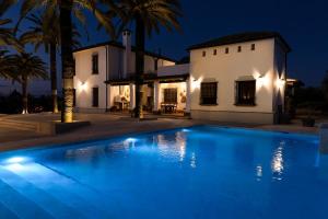 a swimming pool in front of a house at night at Hacienda Los Manchones in Aguilar de la Frontera