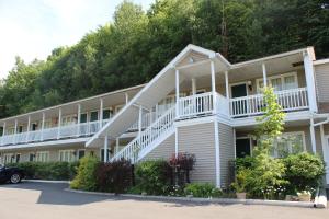 カナーンにあるBerkshire Travel Lodgeの白いバルコニー付きの広い白いアパートメントです。