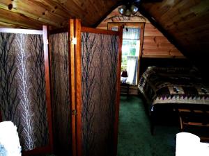 a bedroom with a bed in a wooden cabin at Rustic Woodland Cabin Rental near Oneida Lake, New York in Taberg +11 photos