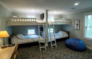 a room with two bunk beds and a desk at Four-Bedroom Luxury House Rental on Pontoosuc Lake in the Berkshires in Lanesborough