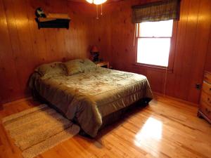 a bedroom with a bed in a room with a window at Deep Creek Lake Cabin Rental with Hot Tub near Terra Alta, West Virginia in Cranesville
