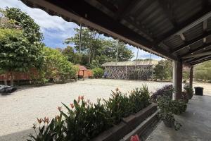 a courtyard with flowers and a pavilion with a building at Inapan Taman Herba in Kepala Batas