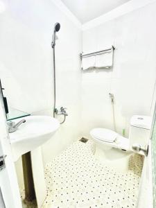 a white bathroom with a toilet and a sink at Thai Binh Motel in Danang