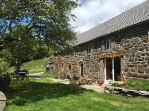 a stone cottage with a table and chairs in front of it at Ciel d'Ardeche in Lachamp-Raphaël