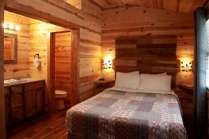 Un dormitorio con una cama en una cabaña de troncos en Stunning Cabin with Hot-tub and Fireplace in Herod, Illinois, en Karbers Ridge