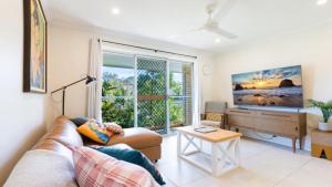 a living room with a couch and a large window at Family Holiday Fun Right Here in Bongaree