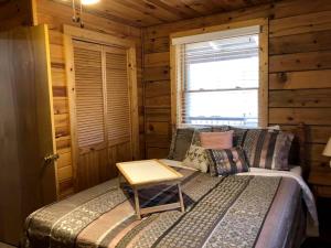 a bedroom with a bed in a log cabin at Rustic Cabin Rental near the Gauley River in West Virginia in Hico