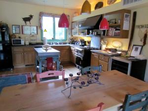 eine Küche mit einem Holztisch und eine Küche mit einem Herd in der Unterkunft Romantic Getaway Cabin with a Pool and a Hot Tub in the Heart of Sonoma, California in Glen Ellen