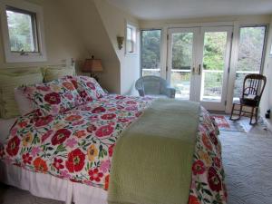 ein Schlafzimmer mit einem Bett mit geblümter Bettdecke in der Unterkunft Romantic Getaway Cabin with a Pool and a Hot Tub in the Heart of Sonoma, California in Glen Ellen