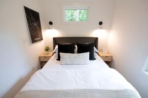 a bedroom with a large white bed with black pillows at Stunning and Fully-Equipped Tiny House with Breathtaking Views of South Cumberland State Park in Monteagle, TN in Monteagle