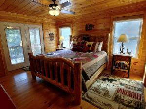 a bedroom with a bed in a log cabin at Incredible Cabin with Fireplace and Hot-tub Next to Hiking Trails in Mineral Bluff, Georgia in Mineral Bluff
