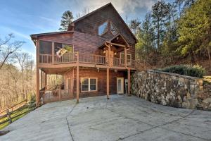 a log home with a deck and a stone wall at Incredible Cabin with Fireplace and Hot-tub Next to Hiking Trails in Mineral Bluff, Georgia in Mineral Bluff
