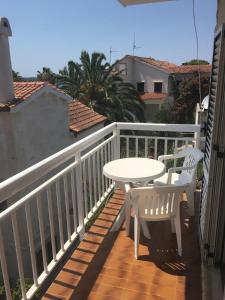 einen weißen Tisch und Stühle auf einem Balkon mit einem Tisch in der Unterkunft Apartment Velada in Hvar