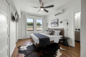Un dormitorio con una cama y un ventilador de techo. en Three Stylish A-Frames Perfect for a Group Escape in Texas, en Fourth Crossing