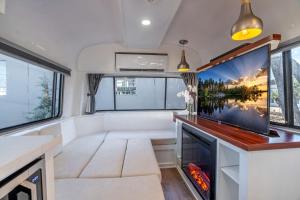 an rv living room with a large screen tv at Prescott AZ Airstream Getaway One Block from Whiskey Row in Prescott
