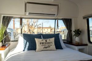 a bed with a pillow on it in a room with a window at Prescott AZ Airstream Getaway One Block from Whiskey Row in Prescott