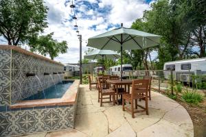 a table and chairs with an umbrella next to a pool at Prescott AZ Airstream Getaway One Block from Whiskey Row in Prescott