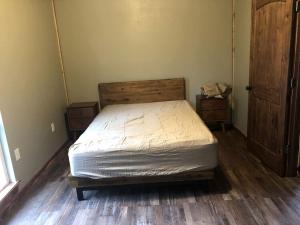 a bedroom with a bed and a wooden floor at Amazing Cabin Rental near Ouachita National Forest for Weekend Getaways in Oklahoma in Hodgen