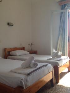 two twin beds in a room with a window at Maria in Skiathos Town
