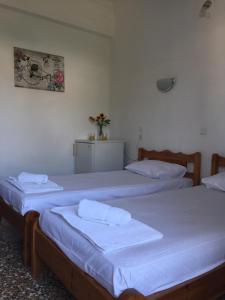 two beds in a room with white walls at Maria in Skiathos Town