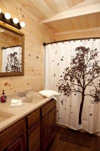 baño con cortina de ducha y árbol en Beautiful Cabin with Hot-tub in Herod, Illinois, en Karbers Ridge