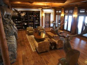 a large living room with a stone wall and a large antlers at Deluxe Vacation Suite with Private Bathroom in Melrose, Montana in Divide