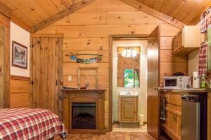 una cocina con chimenea en una cabaña de madera en Treehouse Cabin in Riverton, WV, en Riverton 15 fotos más