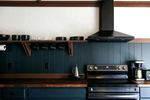 eine Küche mit einem Herd und einer blauen Wand in der Unterkunft Rustic Mountain Cabin with Porch & Fire Pit in New Market, Virginia in New Market