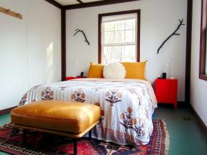 ein Schlafzimmer mit einem Bett und einem Stuhl darin in der Unterkunft Rustic Mountain Cabin with Porch & Fire Pit in New Market, Virginia in New Market