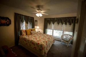 una camera da letto con un letto e un ventilatore a soffitto di Riverfront Cabin with Spacious Interior, Large Deck and Views in Texas a Wimberley