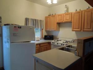 a kitchen with a white refrigerator and wooden cabinets at Lakeside Cabin Rental with a Boat Dock in Pine River, Minnesota in Pine River